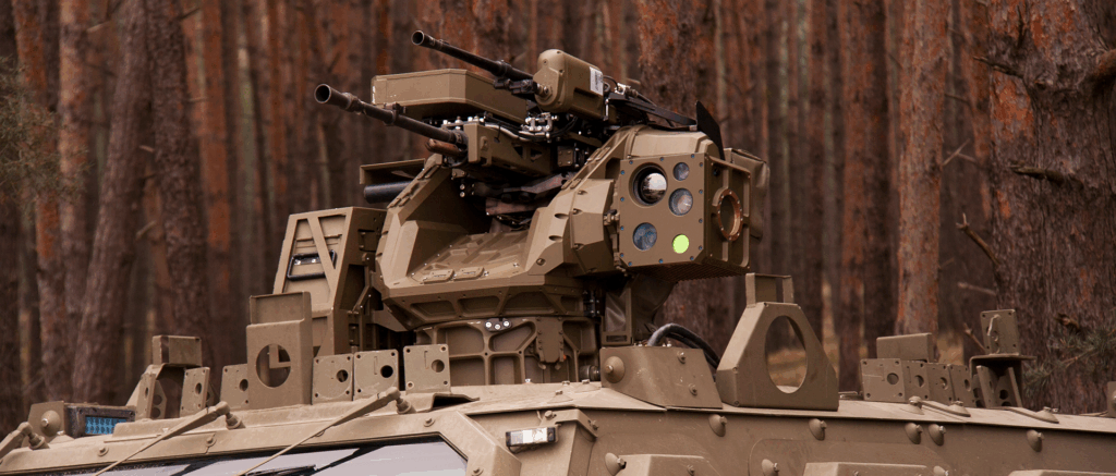 Detail zbraňovej stanice GLADIUS DUAL od EVPÚ s elektrooptickým zameriavačom na obrnenej platforme v lese