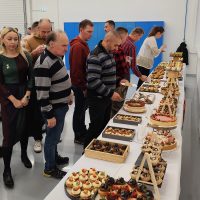 Vianočný punč EVPÚ a.s. – zamestnanci pri slávnostnom stole s dezertmi